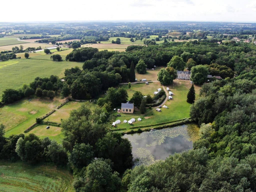 Camping 5 étoiles le Mans Sarthe : domaine de 21 hectares avec son étang, sa piscine, sa forêt et ses espaces verts, vue de haut par drone