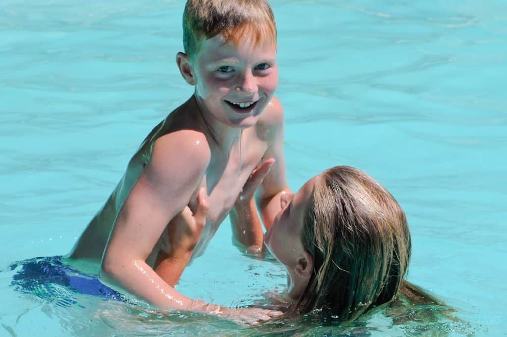 Camping Piscine Sarthe - Camping Château de Chanteloup : frère et soeur qui jouent dans l'eau