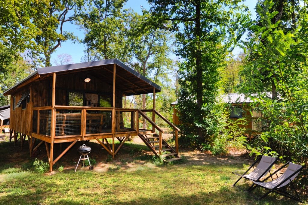 Camping 5 étoiles Château de Chanteloup : vue sur une cabane dans les bois